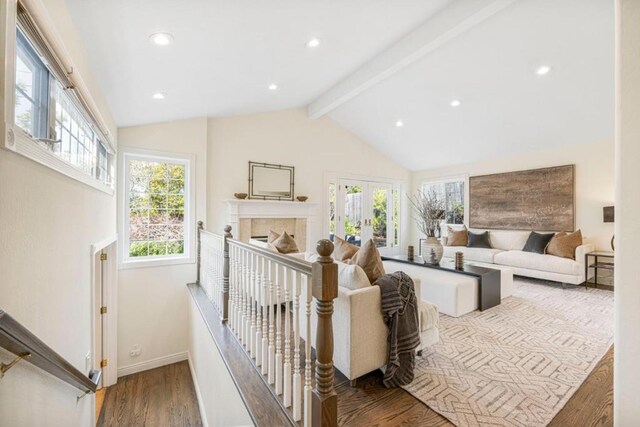 living room with vaulted ceiling with beams, hardwood / wood-style floors, and french doors