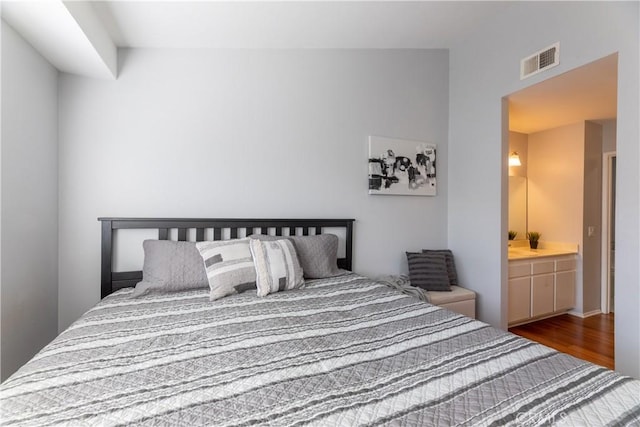 bedroom featuring hardwood / wood-style floors and ensuite bathroom