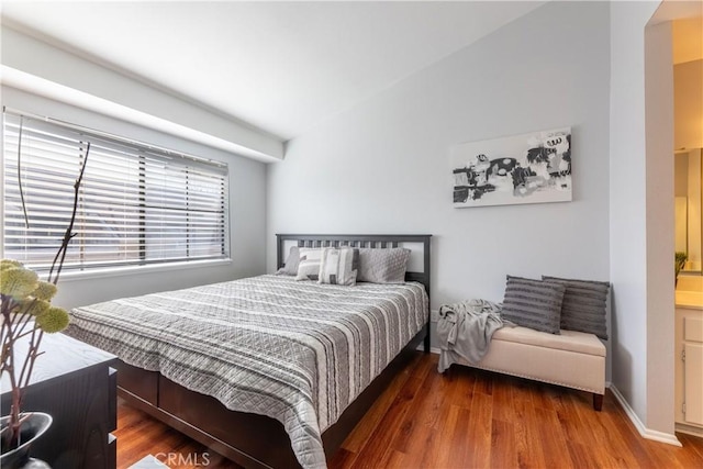 bedroom with hardwood / wood-style flooring and connected bathroom