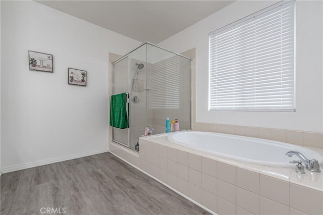 bathroom featuring wood-type flooring and separate shower and tub