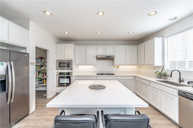 kitchen featuring appliances with stainless steel finishes, a breakfast bar area, sink, and a kitchen island