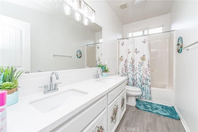 full bathroom with hardwood / wood-style flooring, vanity, toilet, and shower / bath combo with shower curtain