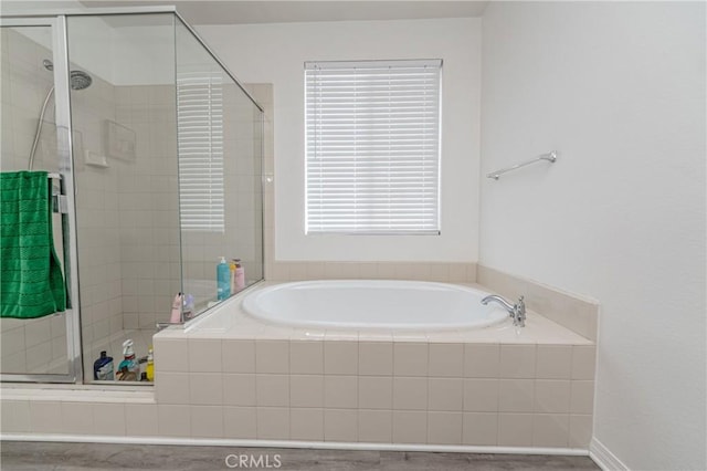 bathroom featuring independent shower and bath and plenty of natural light