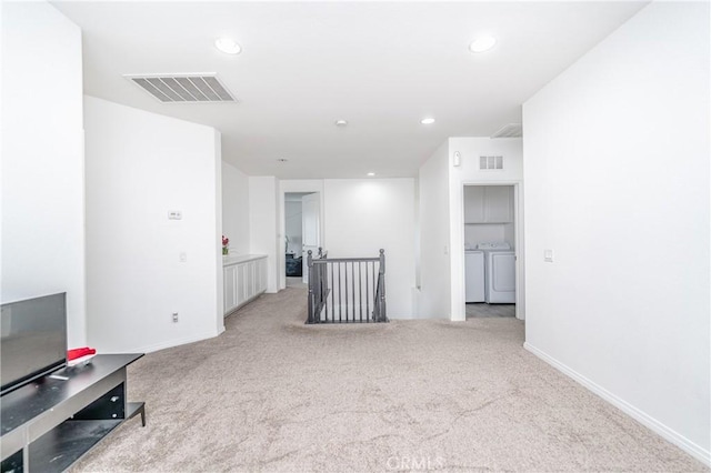 interior space featuring separate washer and dryer and light carpet