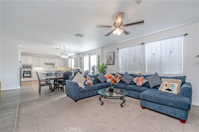 living room with ceiling fan and light wood-type flooring