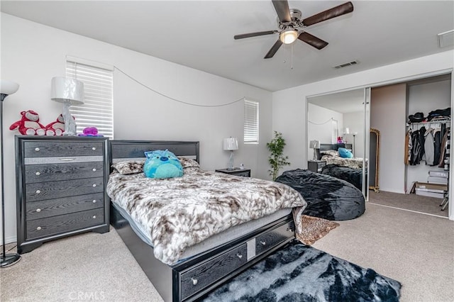 carpeted bedroom with ceiling fan and a closet