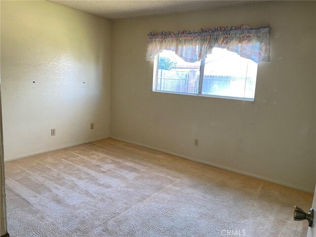 carpeted spare room featuring a textured ceiling