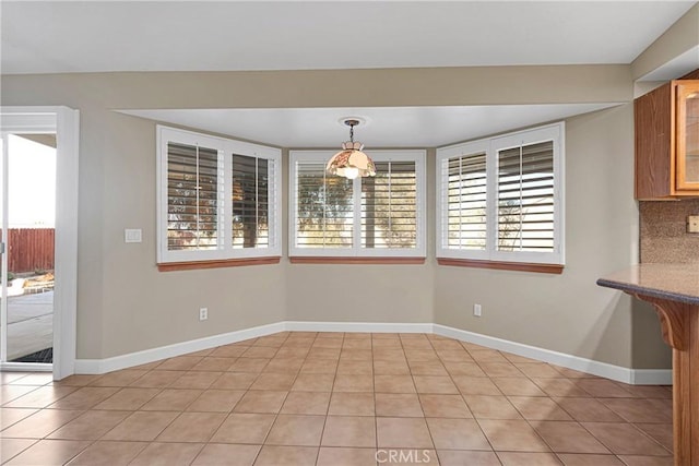 unfurnished dining area with light tile patterned flooring and plenty of natural light