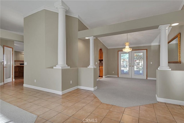 carpeted entryway with ornate columns, ornamental molding, and french doors