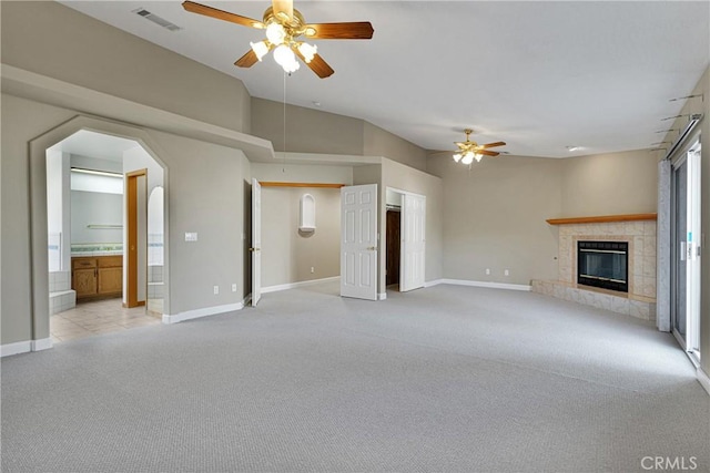 unfurnished living room with a high ceiling, light colored carpet, a fireplace, and ceiling fan