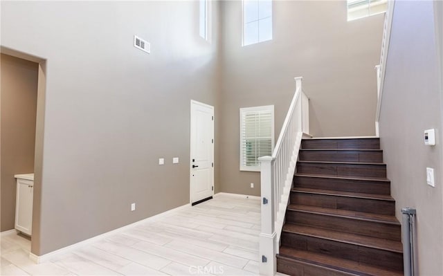 stairs featuring hardwood / wood-style flooring and a high ceiling