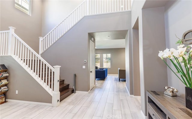 stairway featuring hardwood / wood-style floors and a towering ceiling