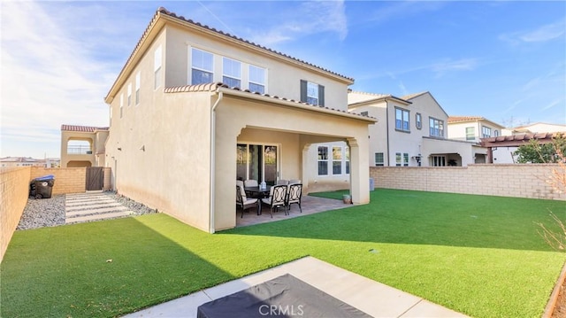 rear view of house featuring a yard and a patio area