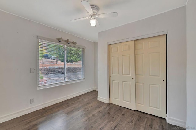 unfurnished bedroom with dark wood-type flooring, a closet, and ceiling fan