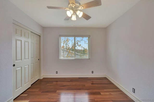 unfurnished bedroom featuring ceiling fan, dark hardwood / wood-style flooring, and a closet