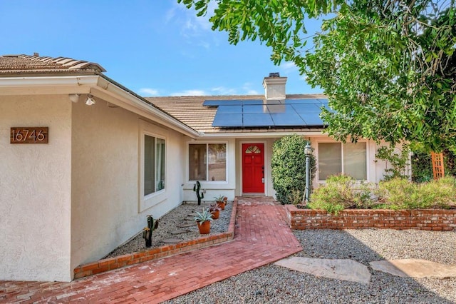 view of exterior entry featuring solar panels