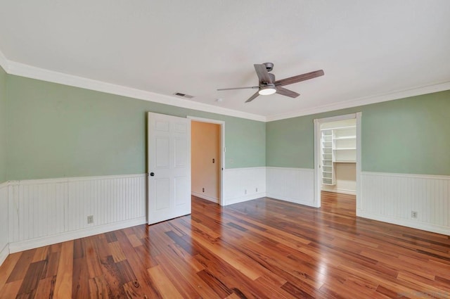 empty room featuring crown molding, ceiling fan, and hardwood / wood-style floors