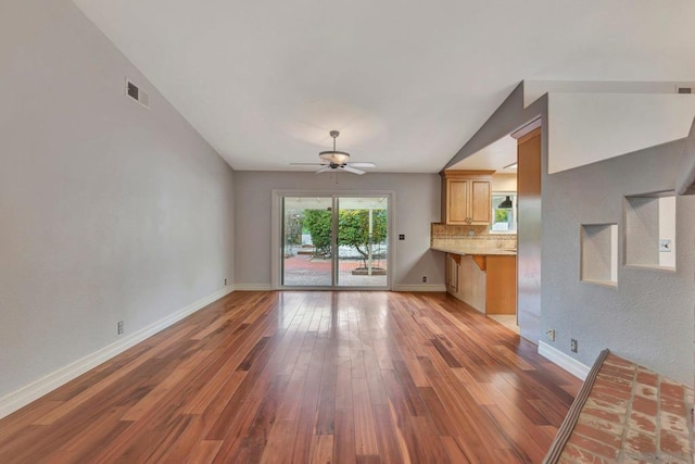 unfurnished living room featuring ceiling fan, vaulted ceiling, and light hardwood / wood-style flooring