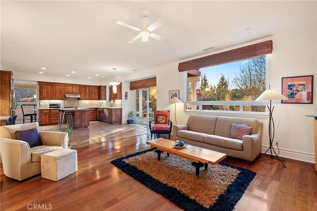 living room with light hardwood / wood-style floors and ceiling fan