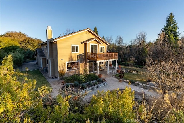 rear view of house featuring a patio area, central air condition unit, and a deck