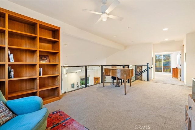 living area with ceiling fan, vaulted ceiling, and light carpet