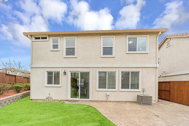 back of property featuring cooling unit, a patio area, and a lawn