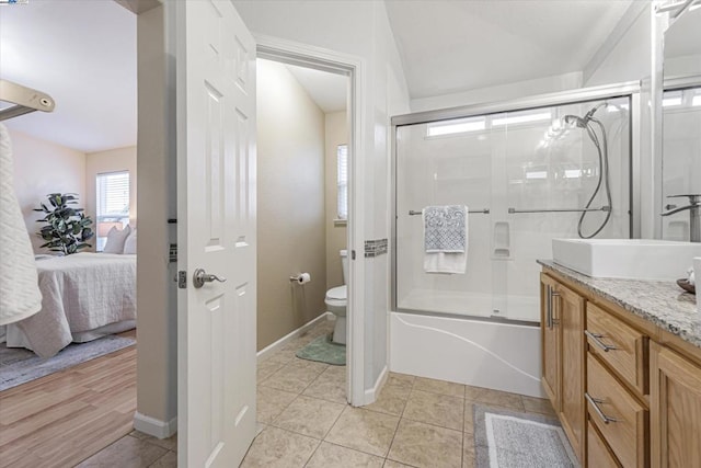 full bathroom featuring bath / shower combo with glass door, vanity, toilet, and tile patterned flooring