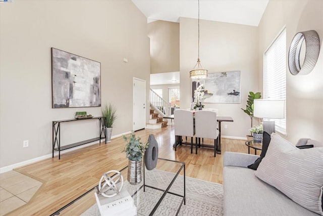 living room featuring a high ceiling, a healthy amount of sunlight, and hardwood / wood-style floors