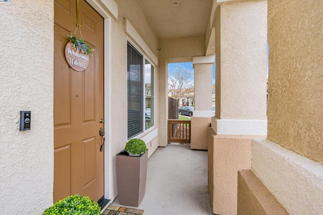 view of exterior entry featuring covered porch