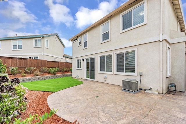 back of house with a patio, central air condition unit, and a lawn