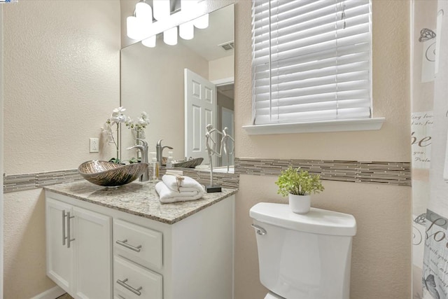 bathroom featuring vanity and toilet