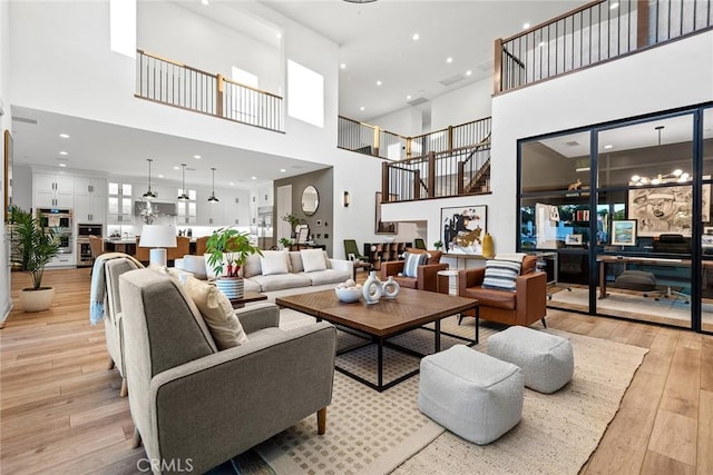 living room featuring a towering ceiling and light hardwood / wood-style flooring