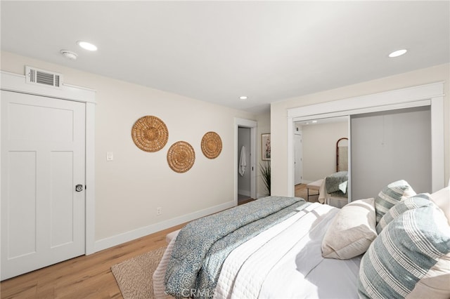 bedroom with light hardwood / wood-style floors and a closet