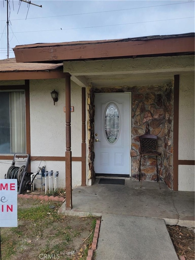 entrance to property featuring stucco siding