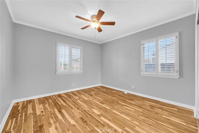 empty room with light wood-style floors, baseboards, and crown molding