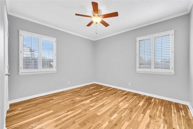 empty room with a ceiling fan, crown molding, light wood-style flooring, and baseboards