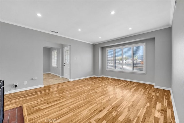 empty room with light wood finished floors, recessed lighting, visible vents, ornamental molding, and baseboards