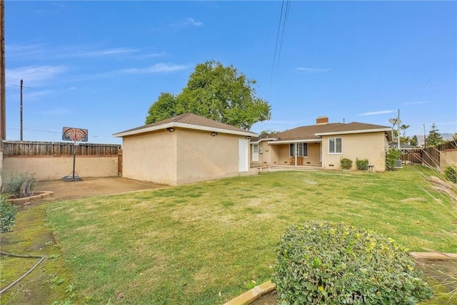 back of house with a patio area, a fenced backyard, a yard, and stucco siding