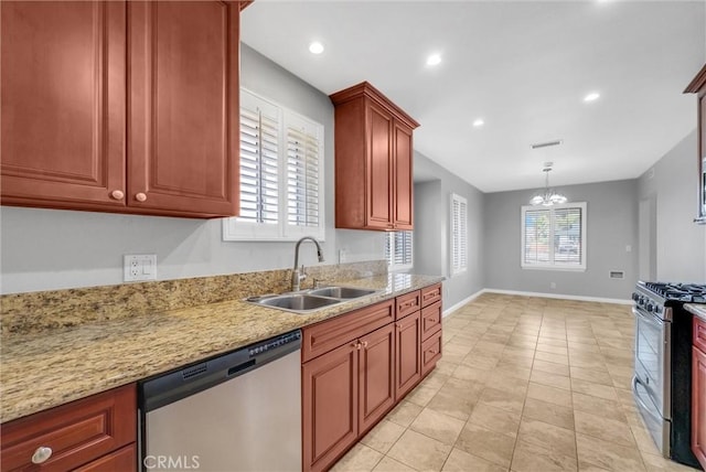 kitchen with sink, an inviting chandelier, light stone counters, appliances with stainless steel finishes, and pendant lighting