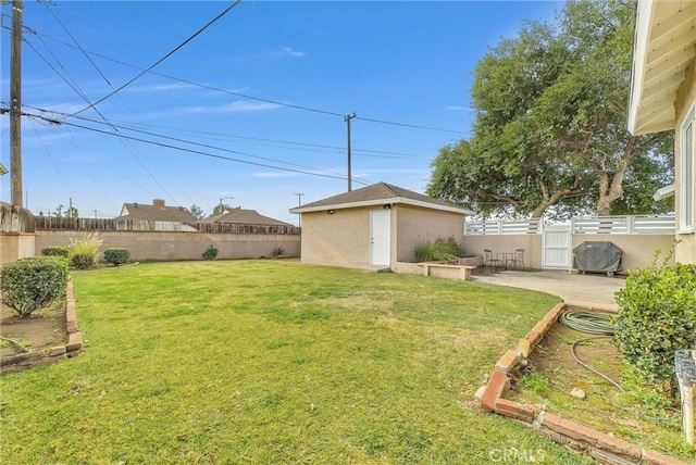 view of yard with a fenced backyard, a patio, and an outdoor structure