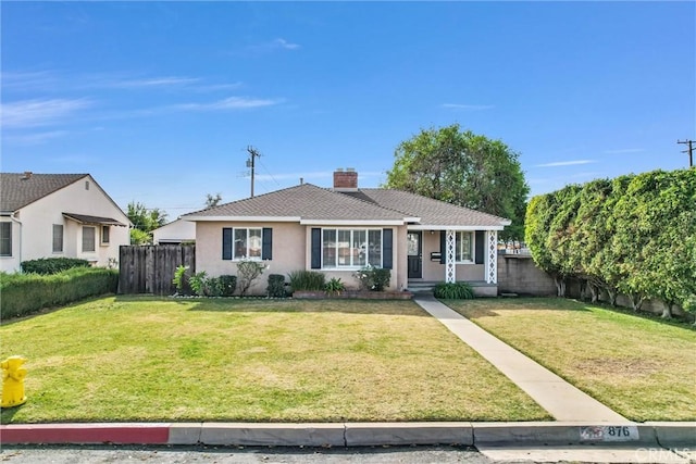 view of front of house featuring a front lawn, a chimney, and fence