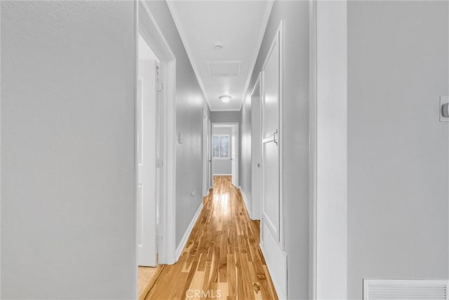 hall featuring ornamental molding and light hardwood / wood-style floors