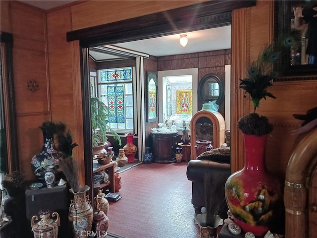 living area featuring carpet floors and wood walls