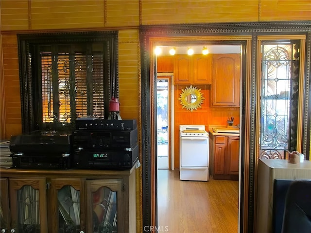 kitchen with sink, light hardwood / wood-style floors, and white range with electric cooktop