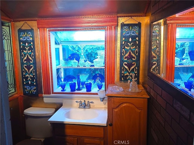 bathroom featuring vanity, plenty of natural light, and toilet