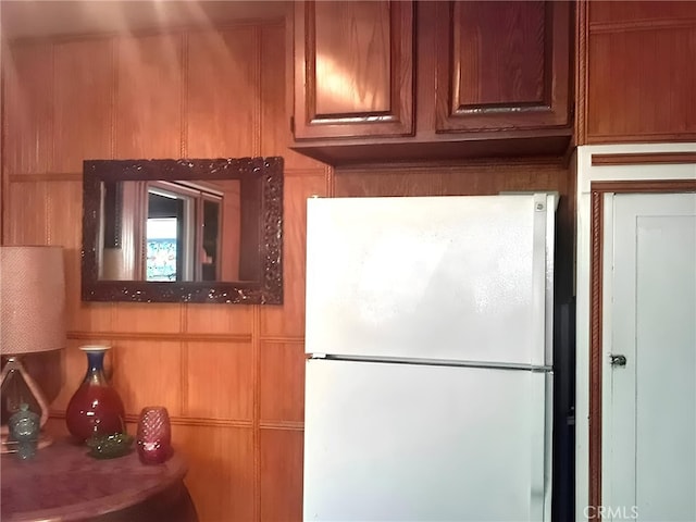 kitchen with wood walls and white fridge