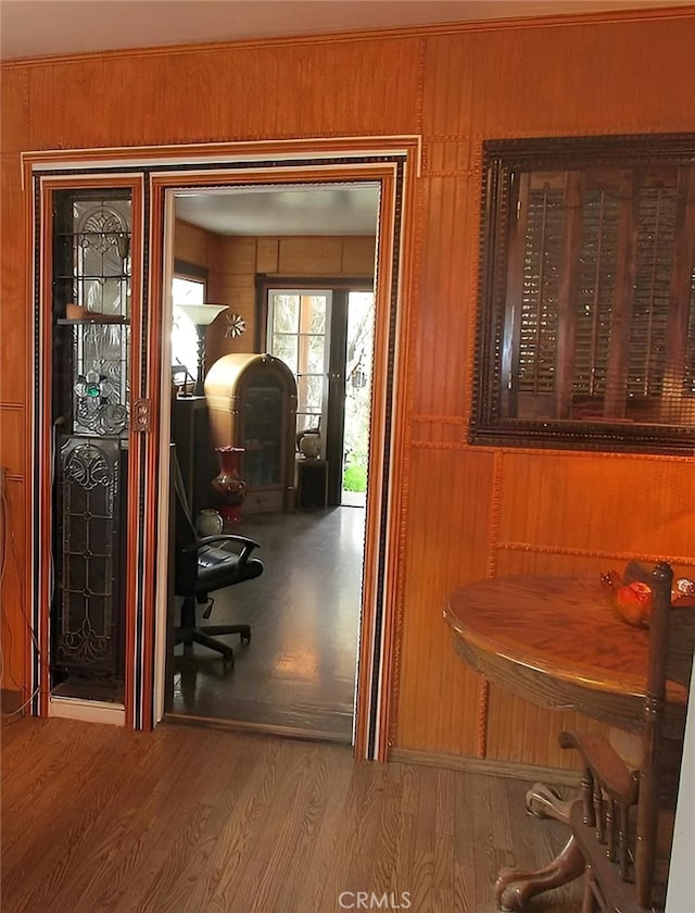 interior space with hardwood / wood-style floors and wooden walls