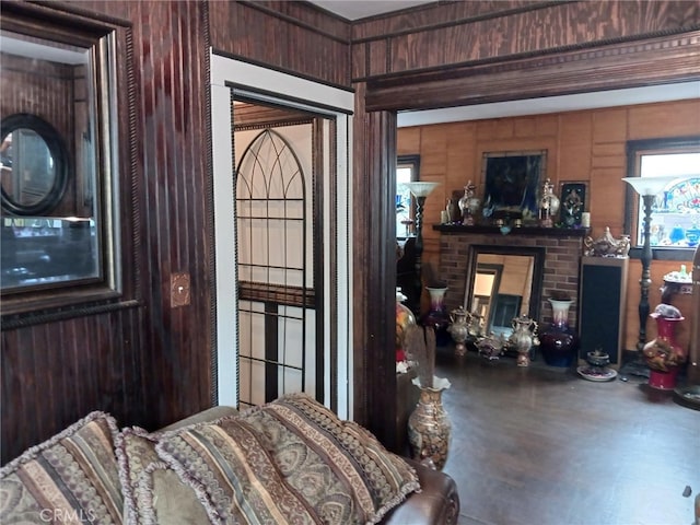 interior space with a brick fireplace and wood walls