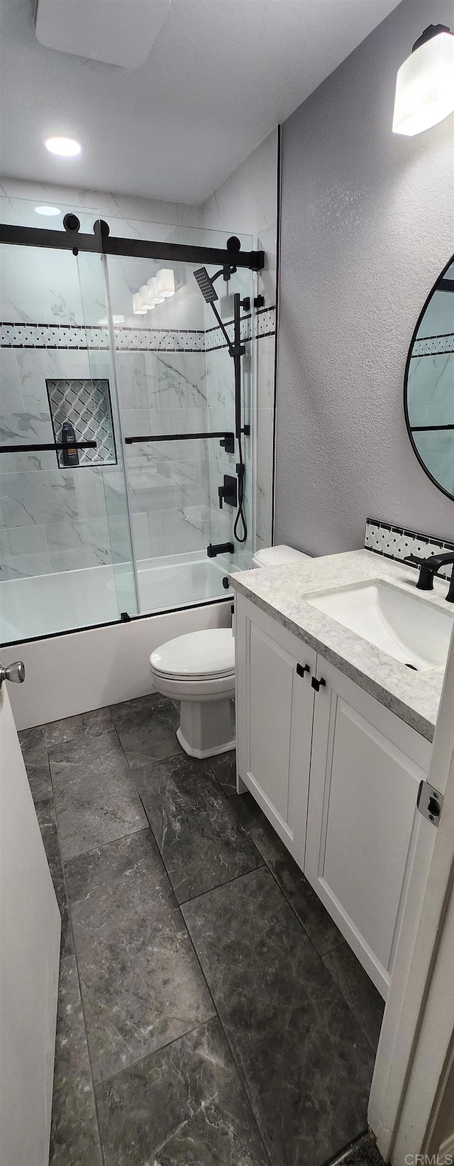 full bathroom featuring vanity, toilet, and combined bath / shower with glass door