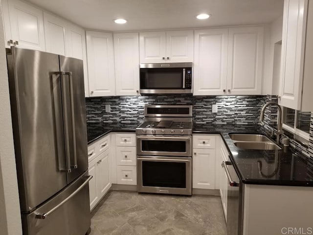 kitchen featuring tasteful backsplash, appliances with stainless steel finishes, sink, and white cabinets